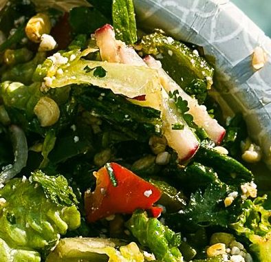 A plate containing grilled chicken leg, a fresh salad with various vegetables, a serving of rice, and a beverage can, placed beside a pool.