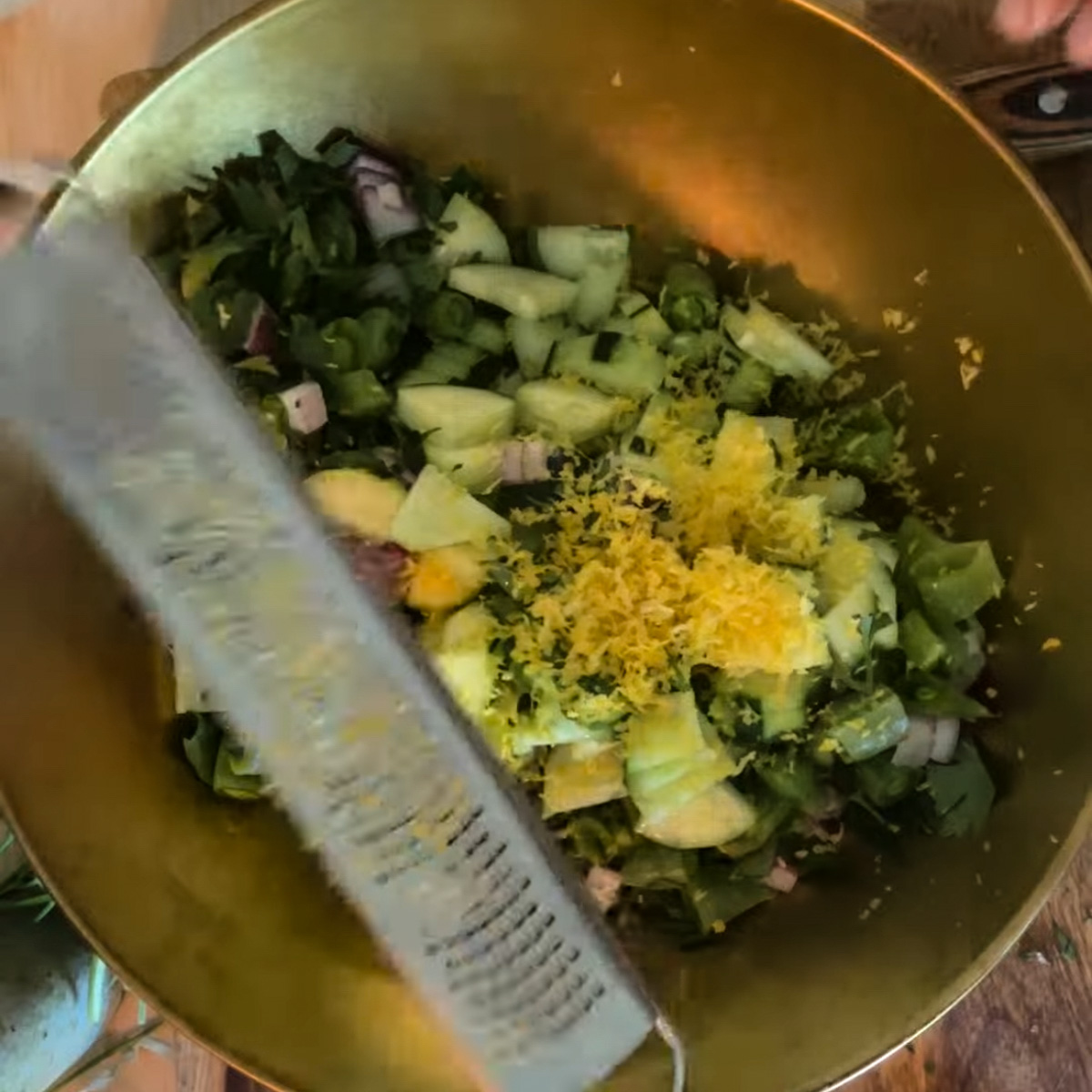Combining dressing and fresh lemon zest with veggies