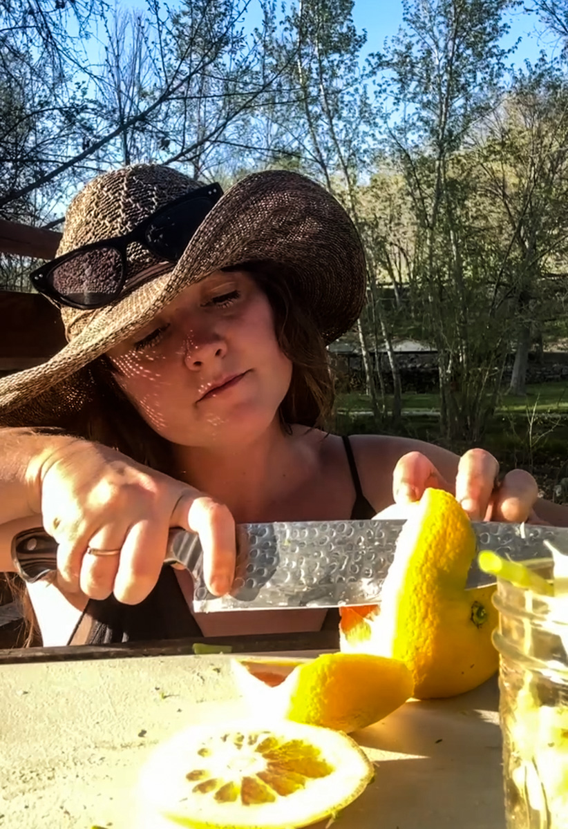 Sam slices oranges, lettuce, and snap peas.